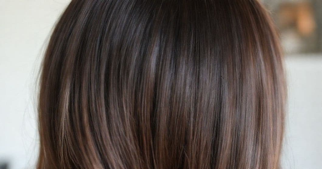 A calm, hopeful person evaluating their hair journey and care routine