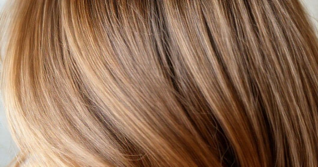 Close-up of hair with a flat iron and a protective spray