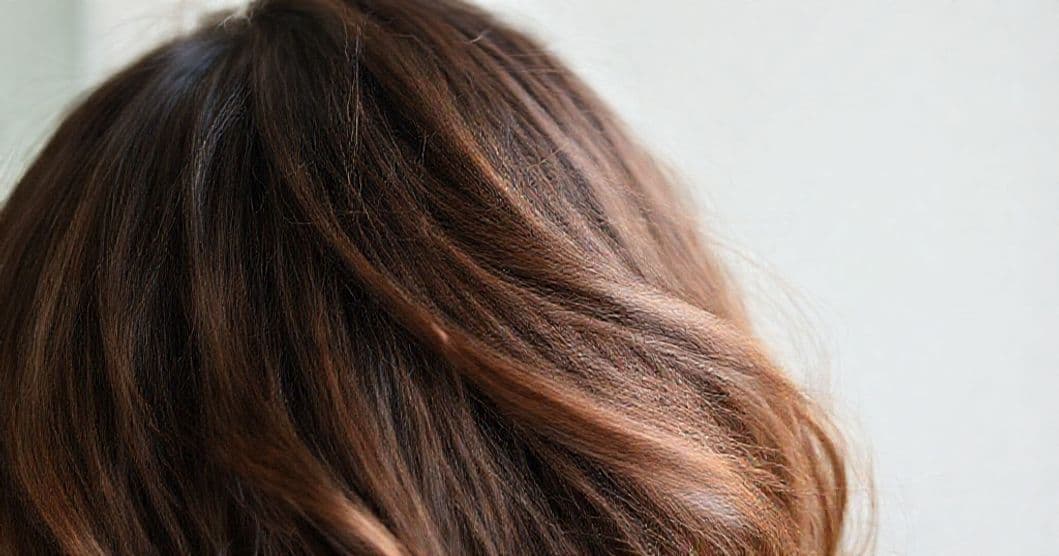 A person gently washing thinning hair, focusing on scalp care